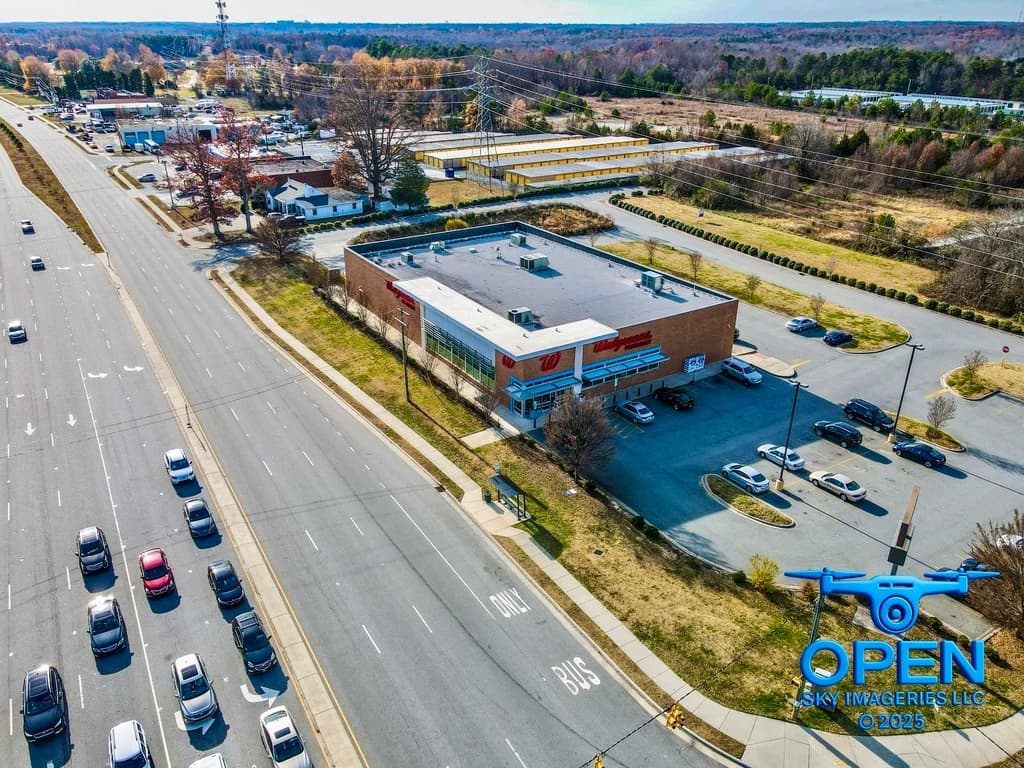 Aerial view of a commercial building with adjacent parking and roads.