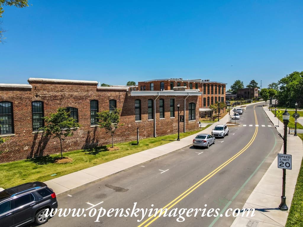Aerial view of a brick building beside a city street.